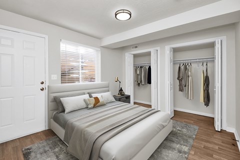 A bedroom with a bed, pillows, and a coat rack.
